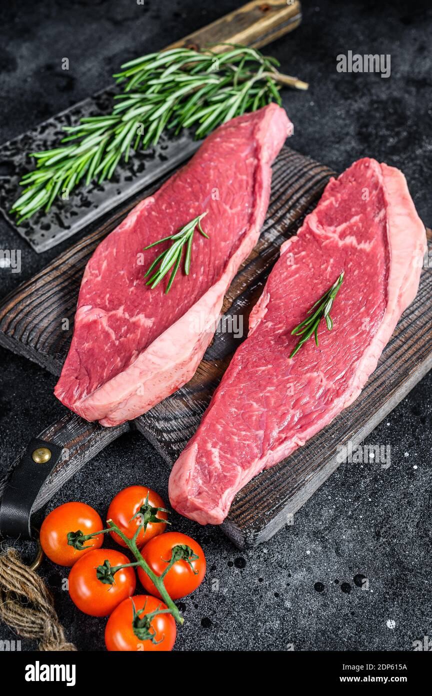 Chapeau de sirloin cru ou steak de picanha. Arrière-plan noir. Vue de dessus. Banque D'Images