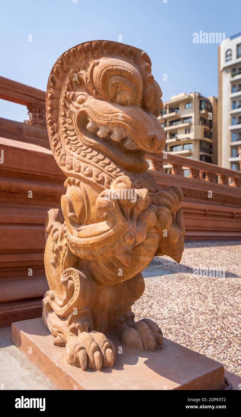 Vue inclinée de la statue du Dragon, une sculpture indonésienne, devant le  Palais du Baron Empain, un manoir historique inspiré du temple hindou  cambodgien d'Angkor Wat, quartier Héliopolis, le Caire, Egypte Photo