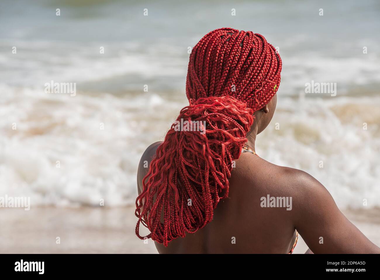 Femme africaine sur une plage aux cheveux rouges au Ghana Afrique de l'Ouest Banque D'Images