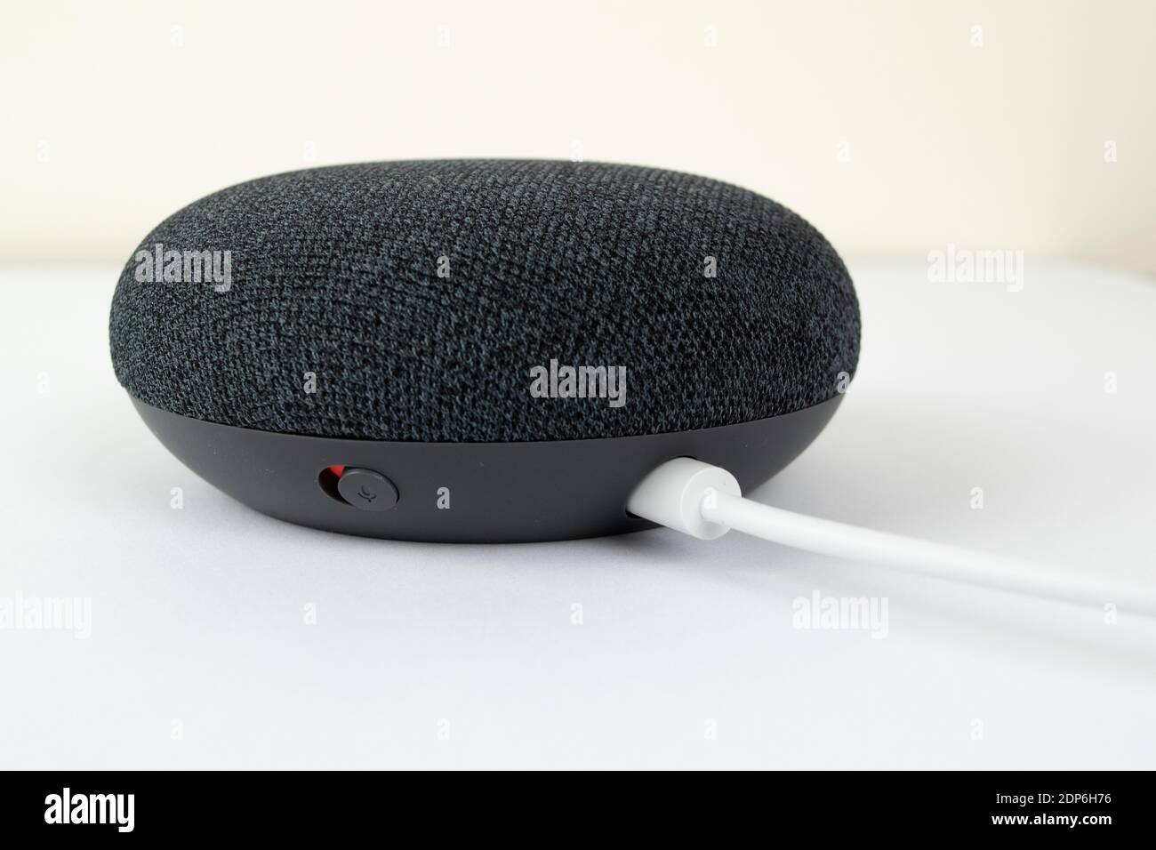 Londres, Royaume-Uni - 19 décembre 2020: Charbon Google Nest Home Mini Smart speaker avec Google Assistant intégré sur un fond blanc. Banque D'Images