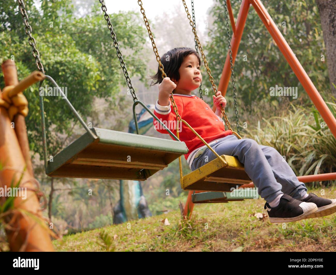 La petite fille asiatique de bébé aime monter un swing à un aire de jeux  Photo Stock - Alamy