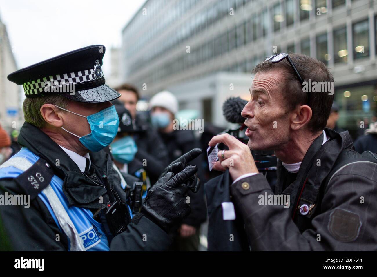 Un homme présente une carte de presse à un policier lors de la manifestation contre le vaccin contre le COVID-19, Westminster, Londres, 14 décembre 2020 Banque D'Images