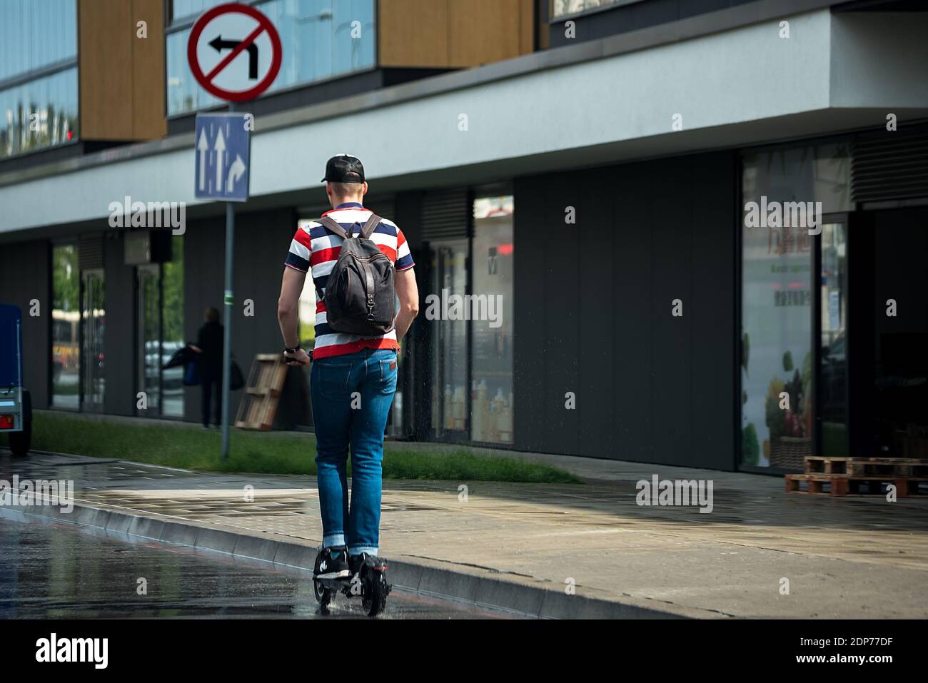 Varsovie, Pologne - 10 juillet 2020 : homme sur un scooter électrique dans la ville. Vue urbaine après la pluie, moyens de transport écologiques. Banque D'Images