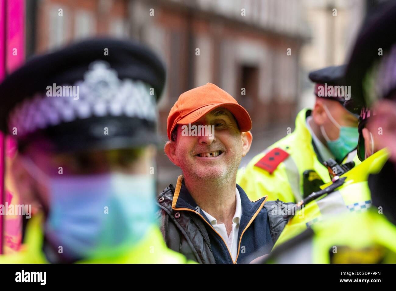 Un manifestant arrêté sourit devant la caméra lors de la manifestation anti-vaccin COVID-19, Westminster, Londres, 14 décembre 2020 Banque D'Images