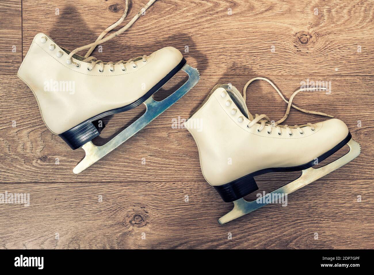 patineuses blanches sur fond de bois. photo teintée Banque D'Images
