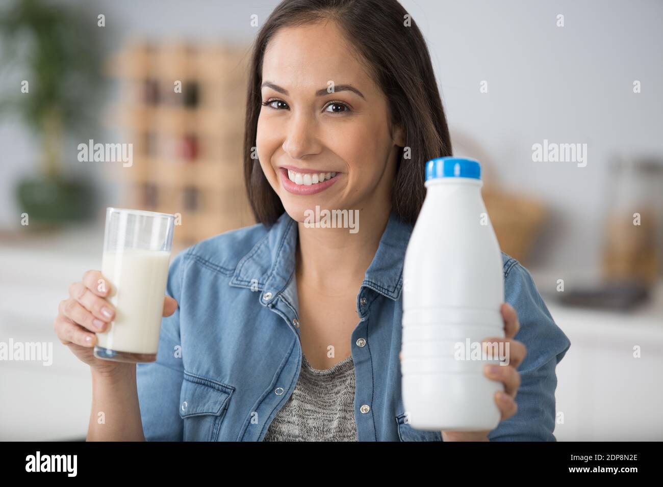 femme tenant un verre et une bouteille de lait en plastique Banque D'Images