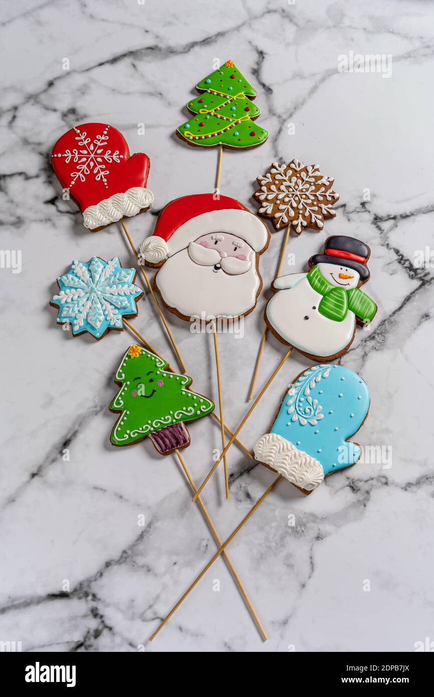 Nourriture de Noël : pain d'épice sur un bâton. Le cerf, l'arbre de noël vert et les biscuits moulés rouges reposent sur le fond de la baie Banque D'Images