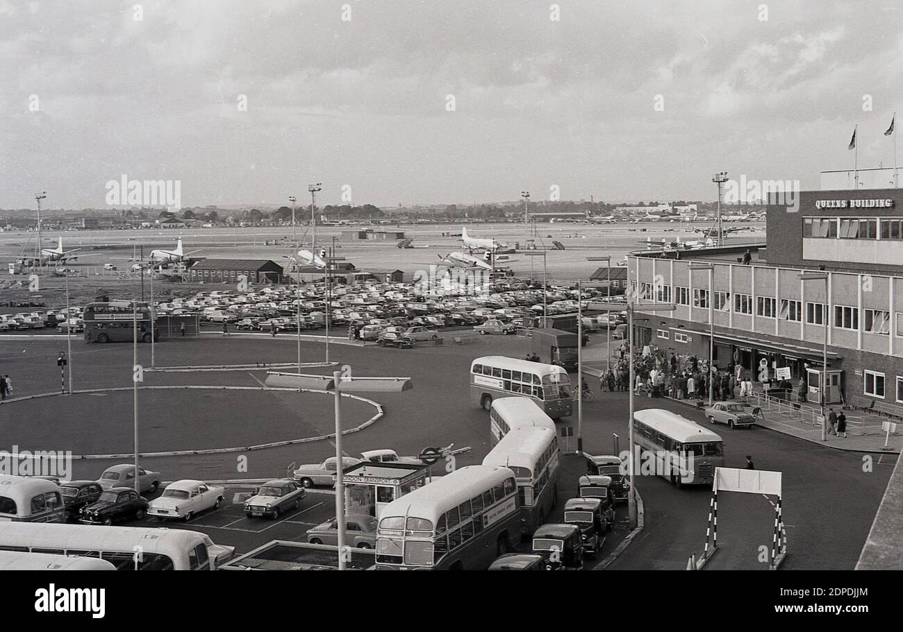 Fin des années 1950, historique, aéroport de Londres, vue extérieure de la zone de la piste avec des avions propulsés et de la zone centrale avec des voitures garées, des bus et des taxis attendant devant le Queens Building, qui abrite l'administration de l'aéroport. L'aéroport sera plus tard renommé Londres Heathrow. Aéroport. Conçu par Frederick Gibberd, le Queen's Building a été officiellement inauguré par la reine Elizabeth II en 1955 et bien que les bureaux de BAA, le bâtiment est devenu une attraction touristique populaire, car il avait des plates-formes d'observation au-dessus de l'aéroport et des jardins sur le toit. Il a été démoli en 2009. Banque D'Images