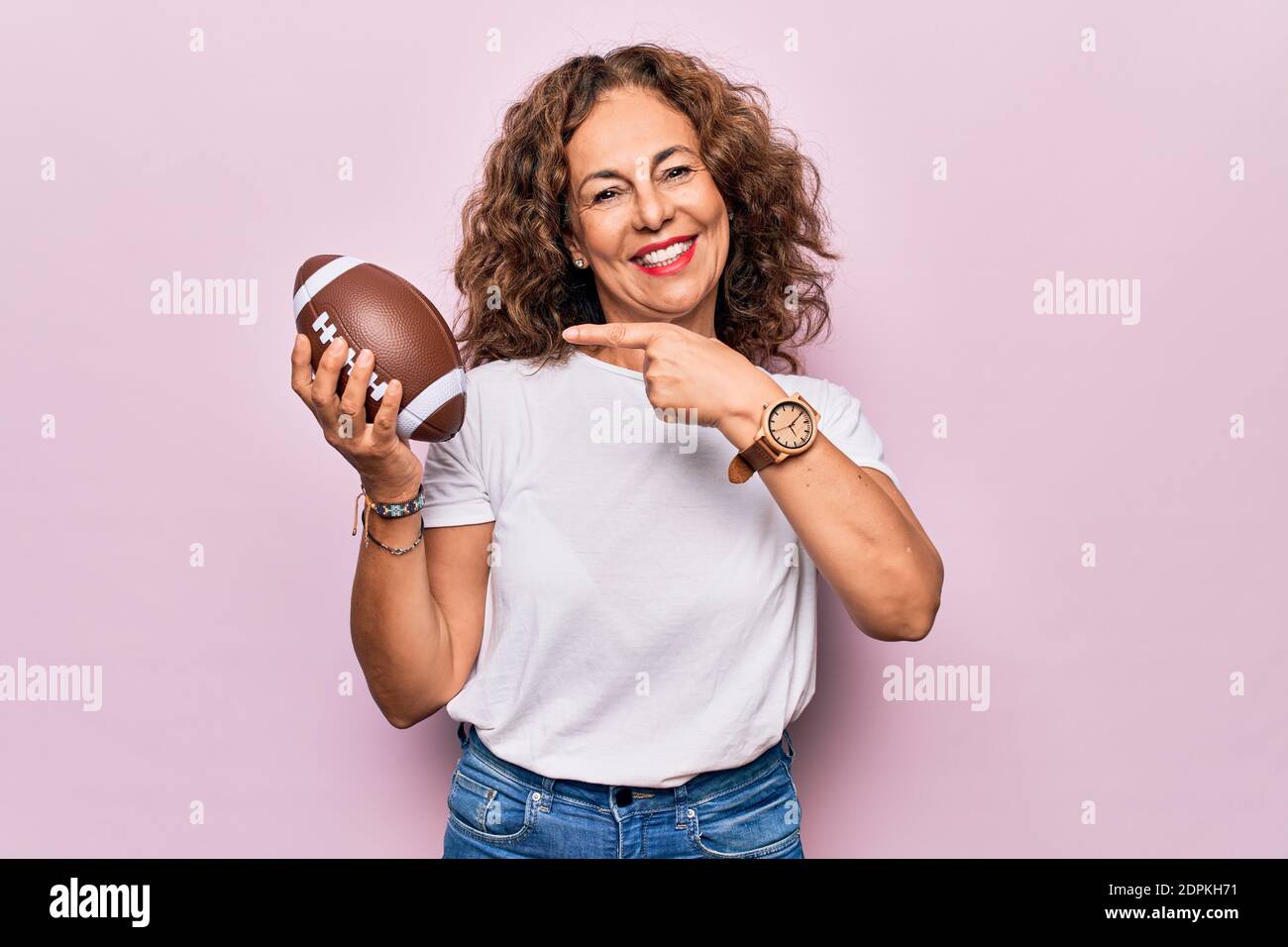 Âge moyen belle femme sportive jouant au rugby tenant le ballon de