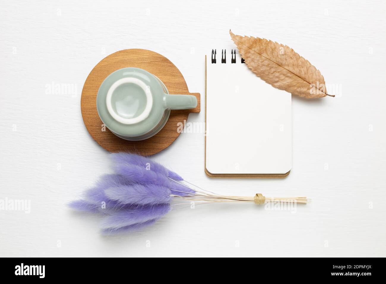 Calepin vide et tasse avec herbe de queue violette sur fond blanc. Vue du dessus, espace de copie. Lieu de travail et d'étude Banque D'Images