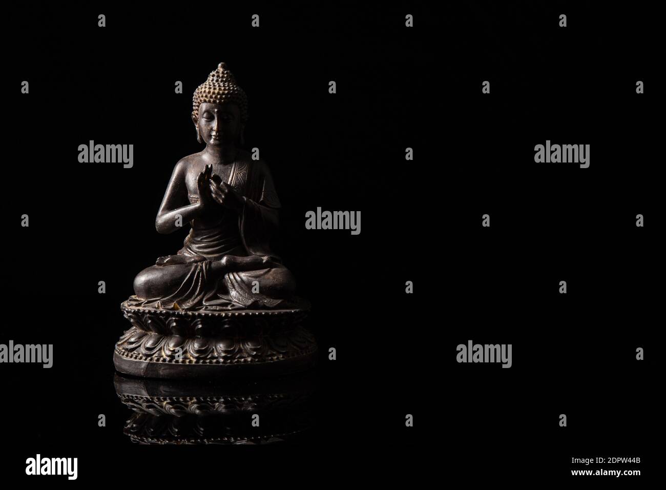 Statue de Bouddha assise dans la méditation avec espace de copie noir . Concept Zen et méditation. Banque D'Images