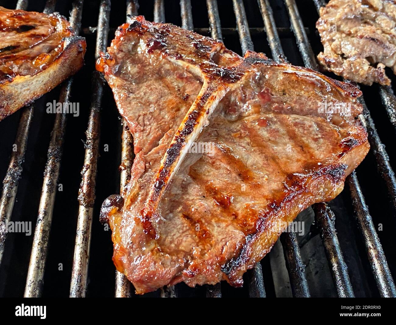 Le processus de griller de délicieux steaks sur le gril extérieur Banque D'Images