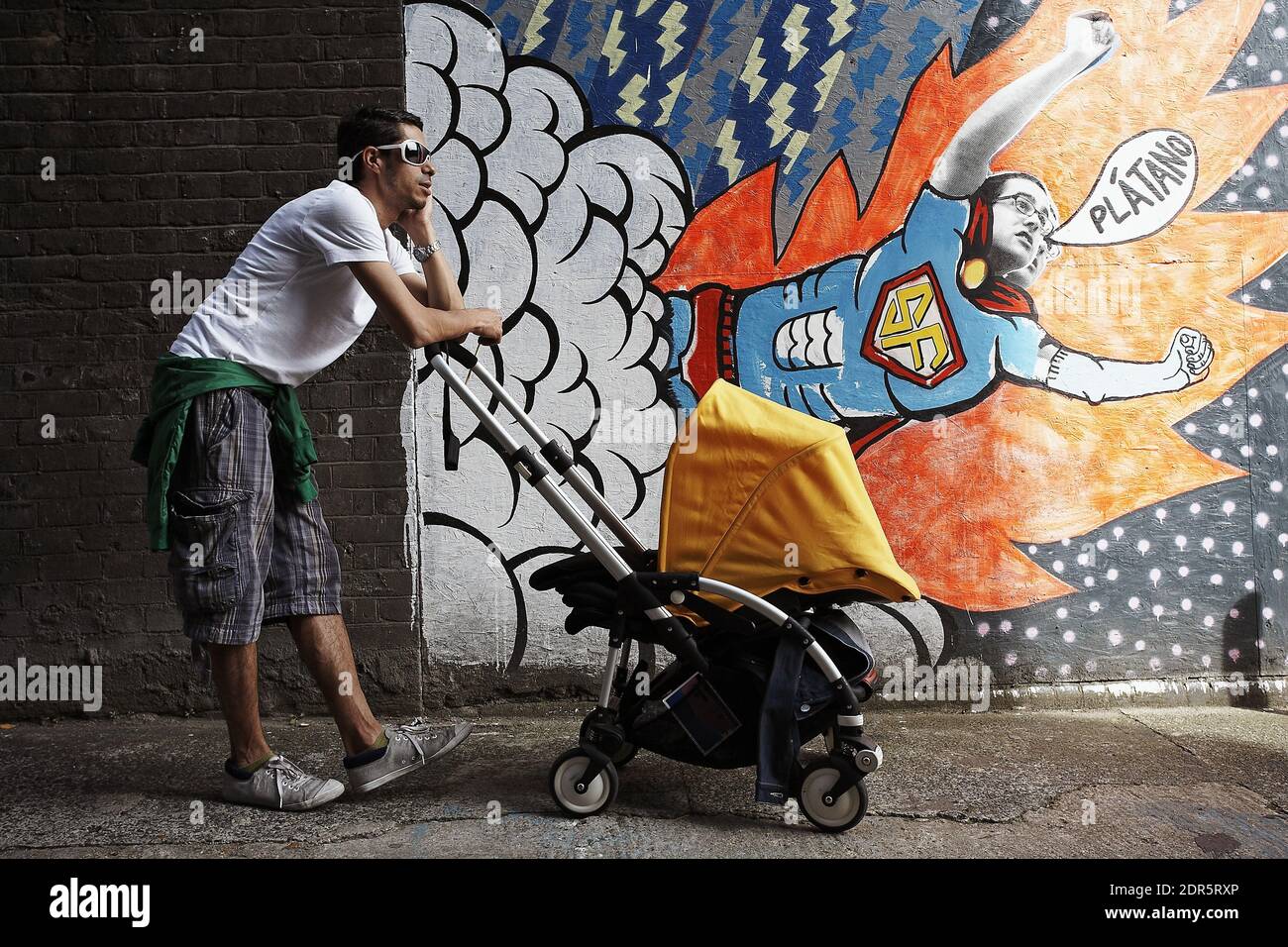 GRANDE-BRETAGNE / Londres / Père poussant son bébé dans un buggy tout en parlant sur son téléphone mobile.Homme parlant sur téléphone mobile avec bébé dans poussette . Banque D'Images