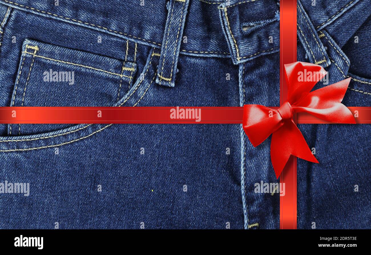 Vêtements, chaussures et accessoires - vue de face gros plan fragment bleu jeans cadeau noué noeud rouge Banque D'Images