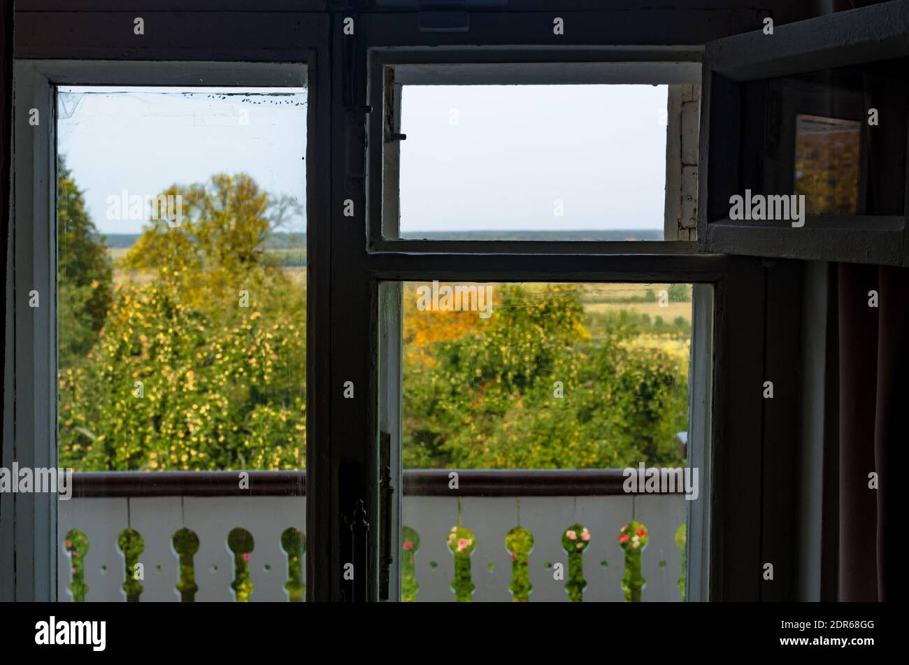 Vue sur un verger de pomme à travers une vieille fenêtre, foyer sur le cadre de fenêtre, paysage non focalisé Banque D'Images