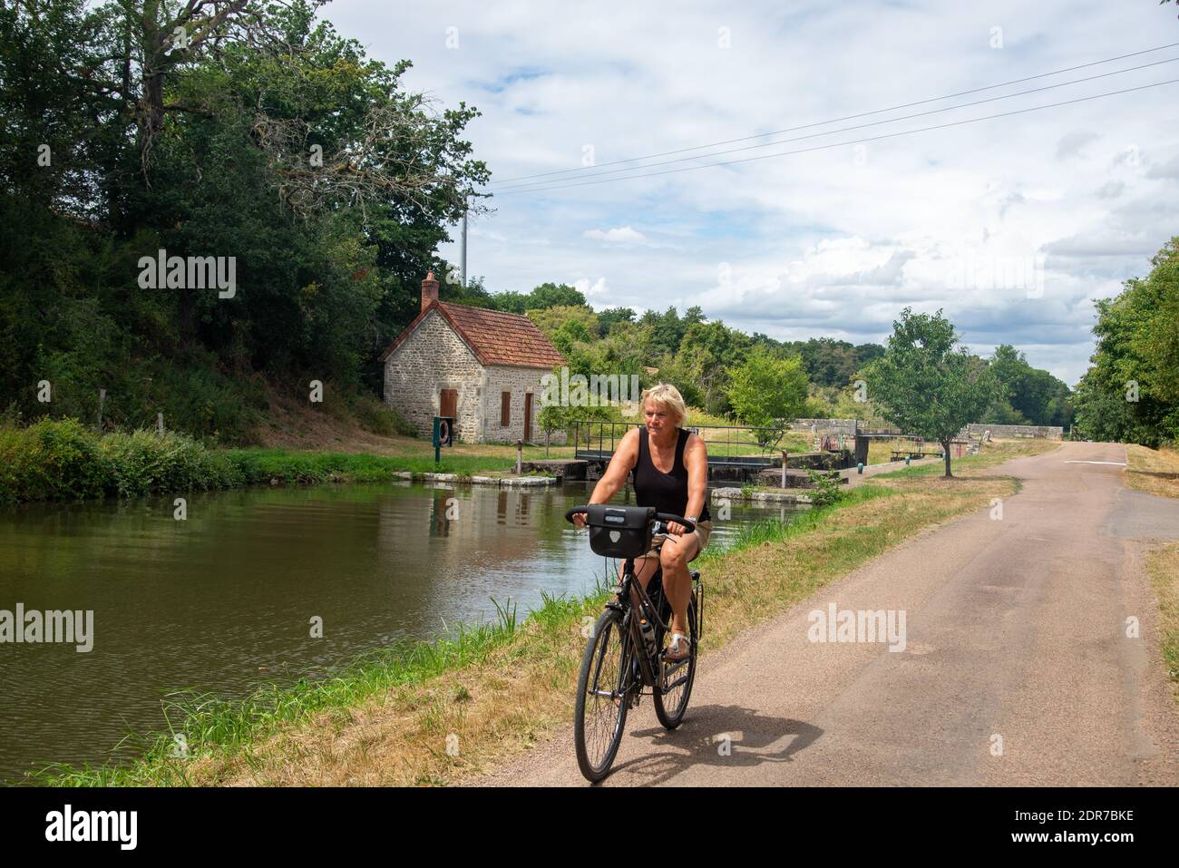 Cycliste le long du canal de Nivernais à Morvan, en France Banque D'Images