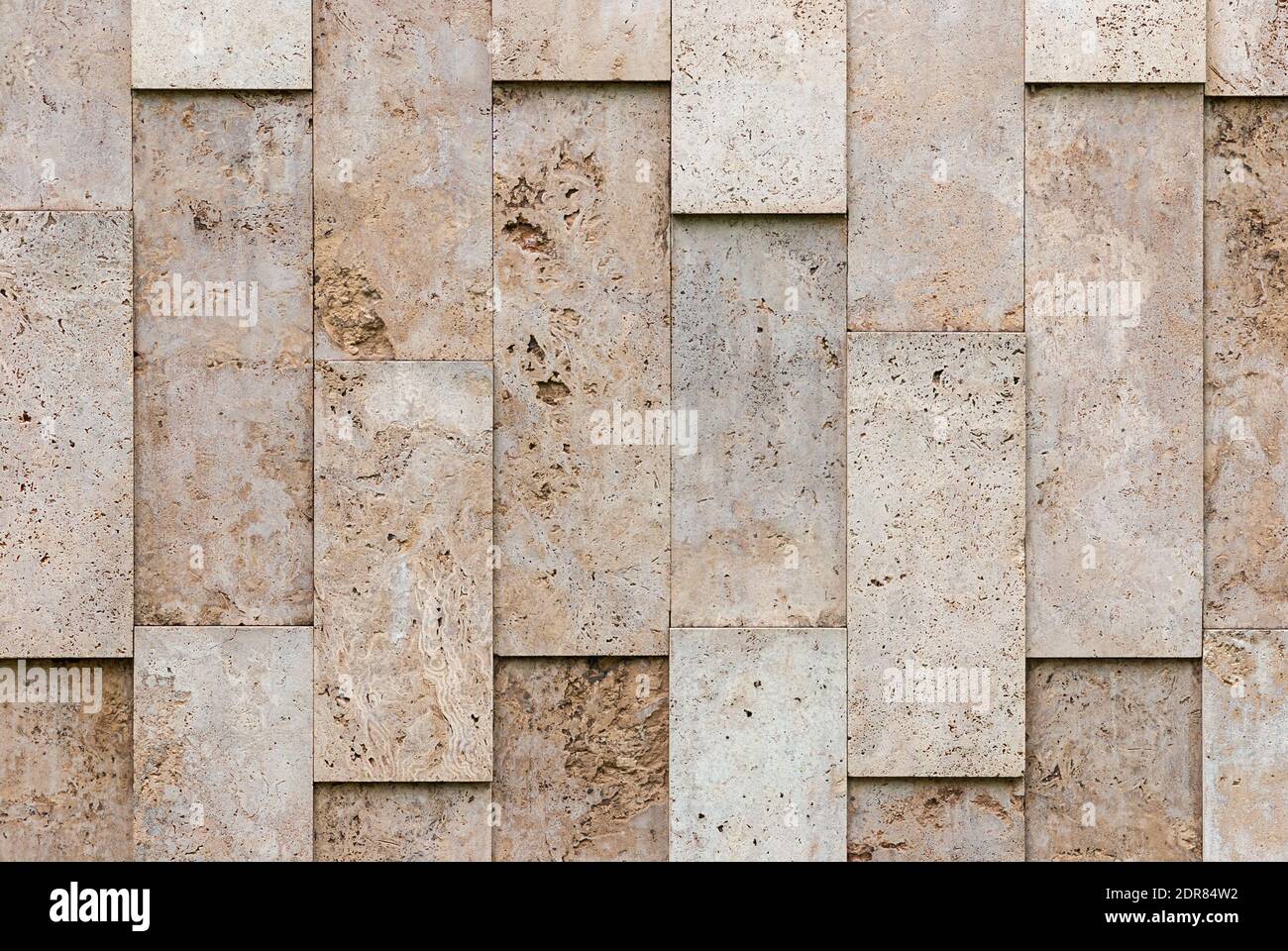 mur beige-gris de blocs de pierre naturels texturés, disposition irrégulière Banque D'Images