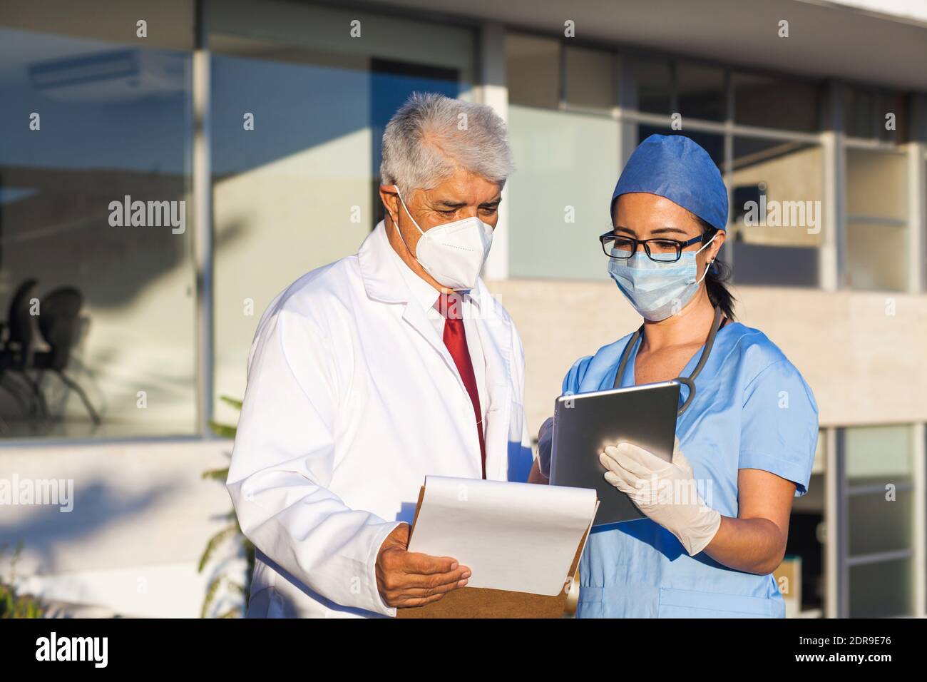 L'équipe latine de médecins regardent la caméra et Souriant en se tenant à l'extérieur de l'hôpital mexicain dans la ville de Mexico ou amérique latine Banque D'Images