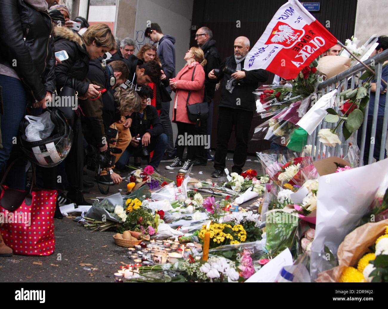 Des gens laissent des fleurs le long d'un cordon ferroviaire près du théâtre Bataclan dans le 11ème arrondissement de Paris le 14 novembre 2015, au moins 129 personnes ont été tuées et 352 autres blessées -- 99 d'entre elles dans un état critique -- après les attaques terroristes à Paris le 13 novembre. Photo de Somer/ABACAPRESS.COM Banque D'Images