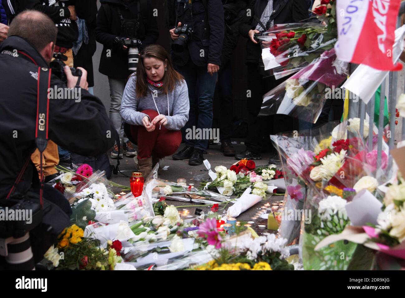 Des gens laissent des fleurs le long d'un cordon ferroviaire près du théâtre Bataclan dans le 11ème arrondissement de Paris le 14 novembre 2015, au moins 129 personnes ont été tuées et 352 autres blessées -- 99 d'entre elles dans un état critique -- après les attaques terroristes à Paris le 13 novembre. Photo de Somer/ABACAPRESS.COM Banque D'Images