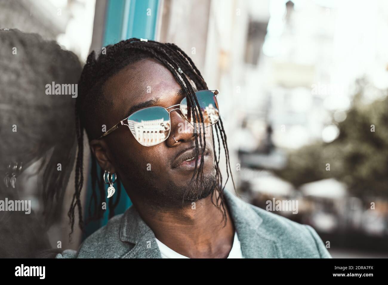 Jeune homme tendance portant des lunettes de soleil en ville Photo Stock -  Alamy