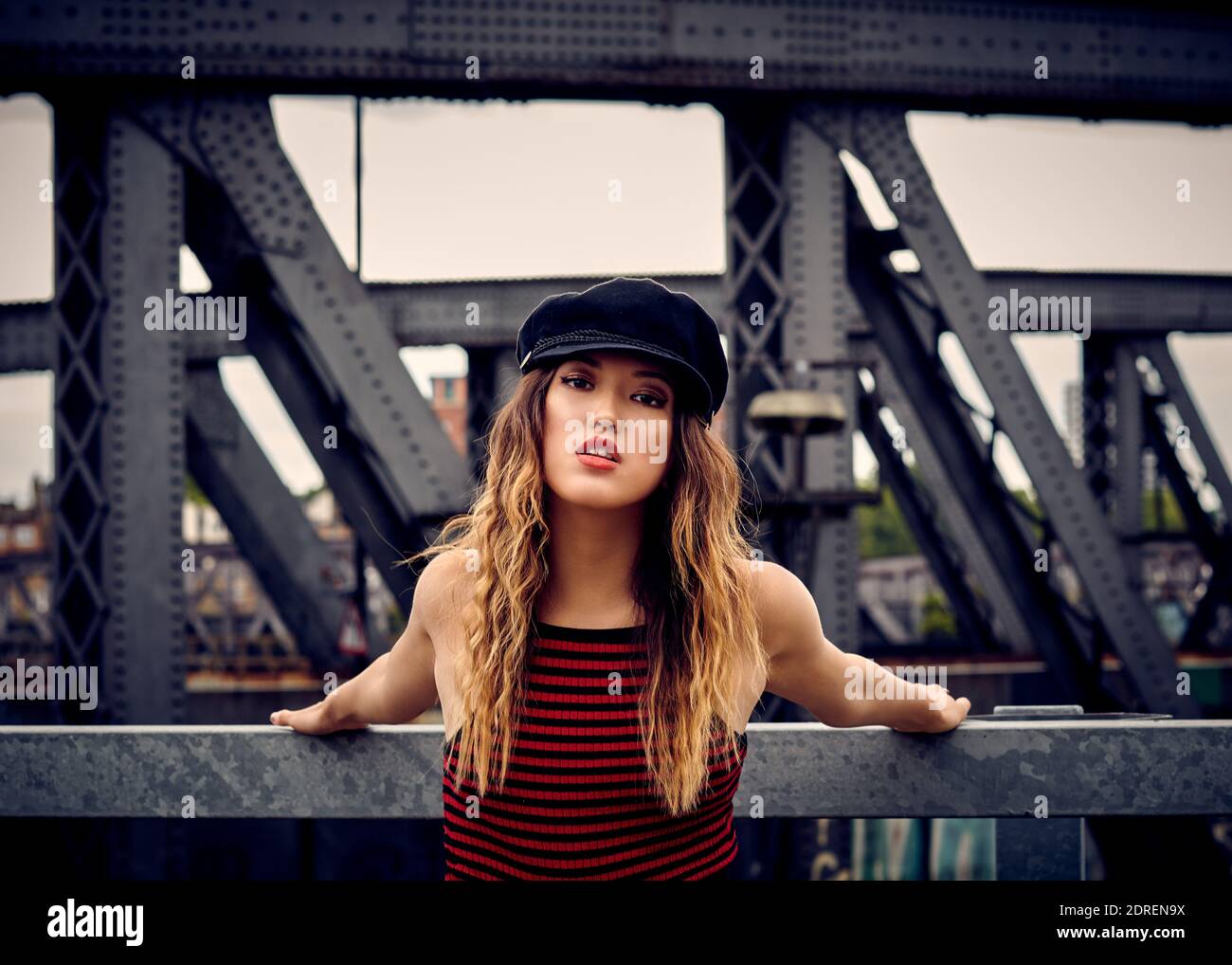 Portrait d'une jeune femme qui porte une casquette plate contre une  structure construite Photo Stock - Alamy