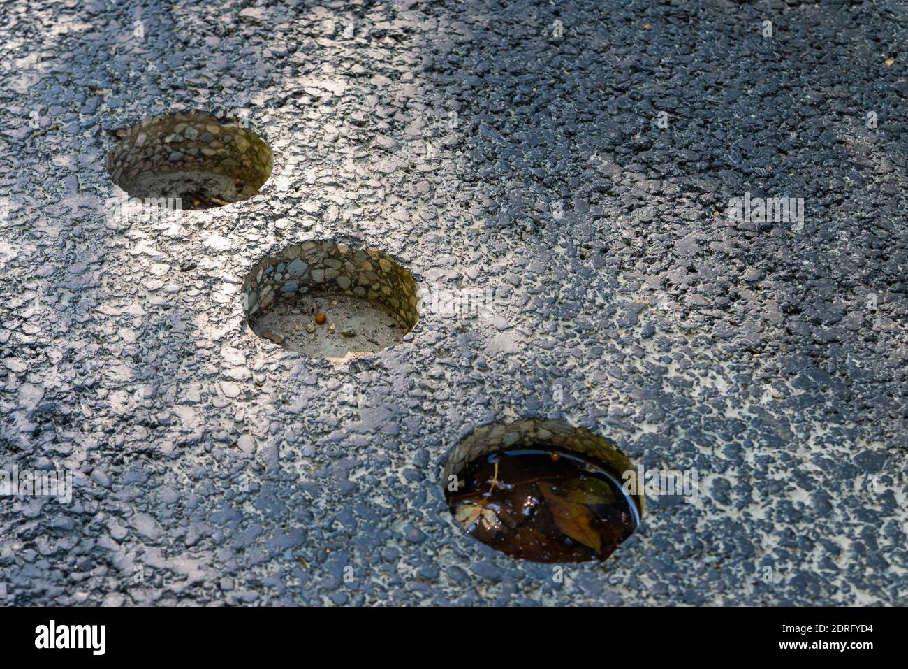 Trous dans la chaussée asphaltée, échantillon cylindrique percé pour les essais en laboratoire. Banque D'Images