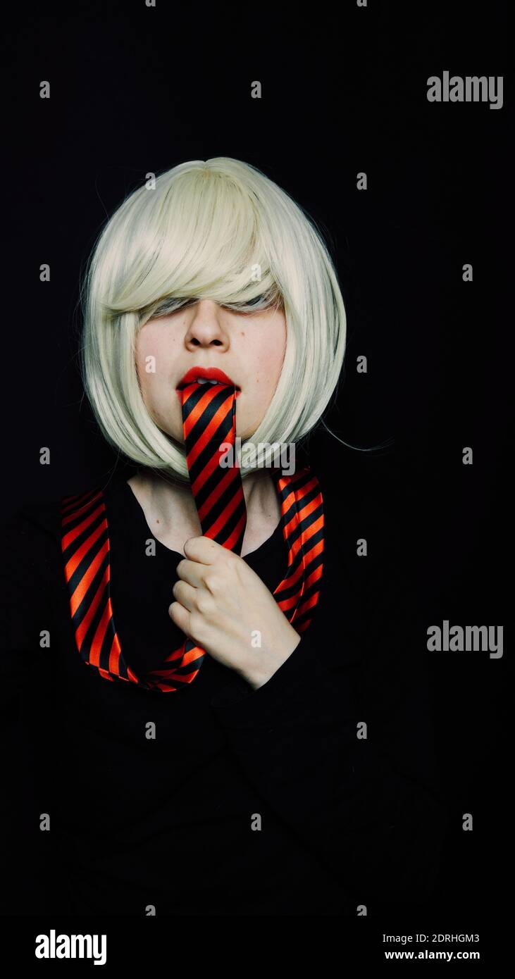 Portrait d'une femme adulte de taille moyenne avec cravate dans la bouche  contre fond noir Photo Stock - Alamy