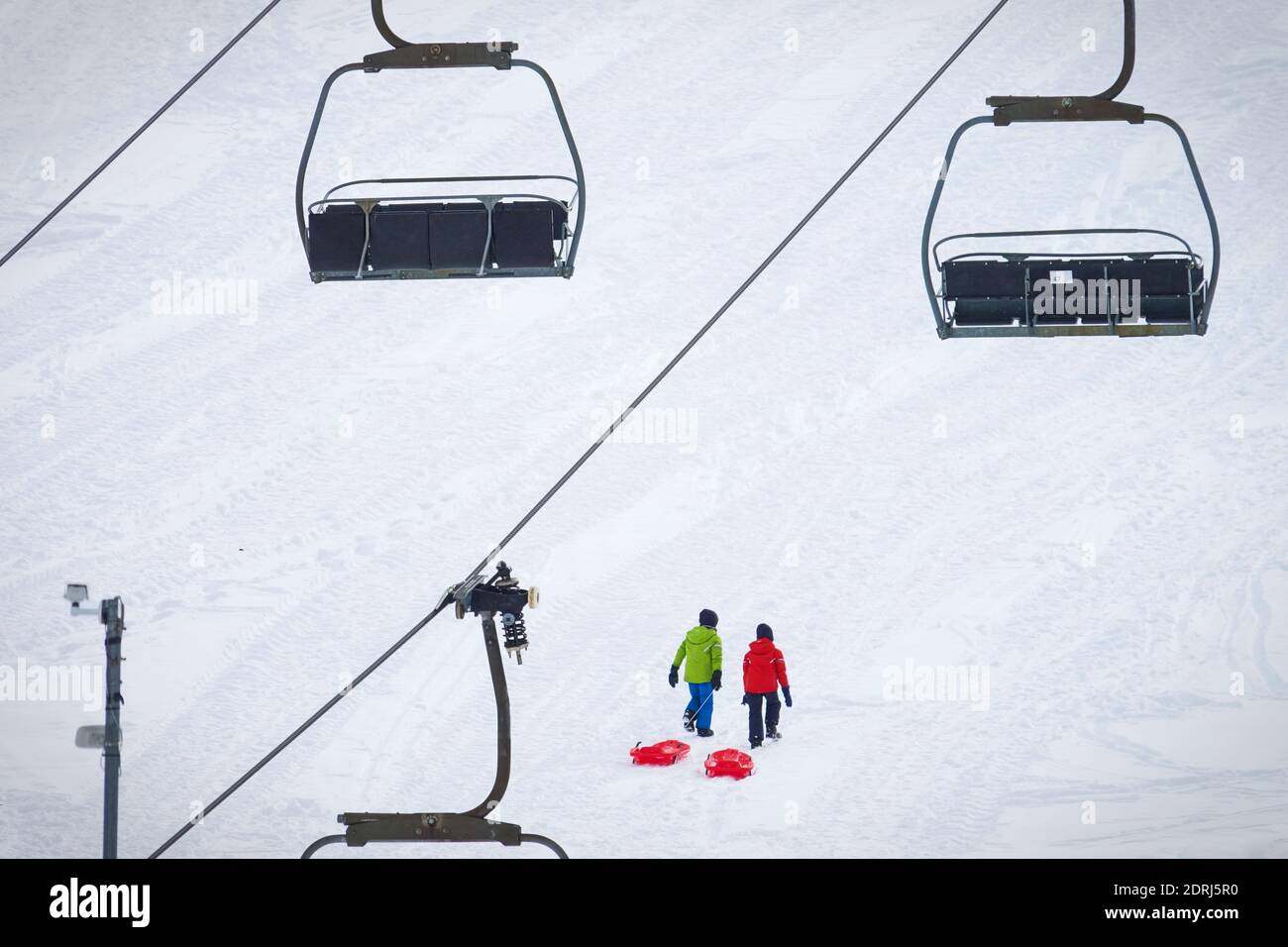 Les pistes de ski sont fermées en raison d'une pandémie à Noël, peu de touristes avec des enfants jouent dans la neige avec des bobsleighs. Sestriere, Italie - décembre 2020 Banque D'Images