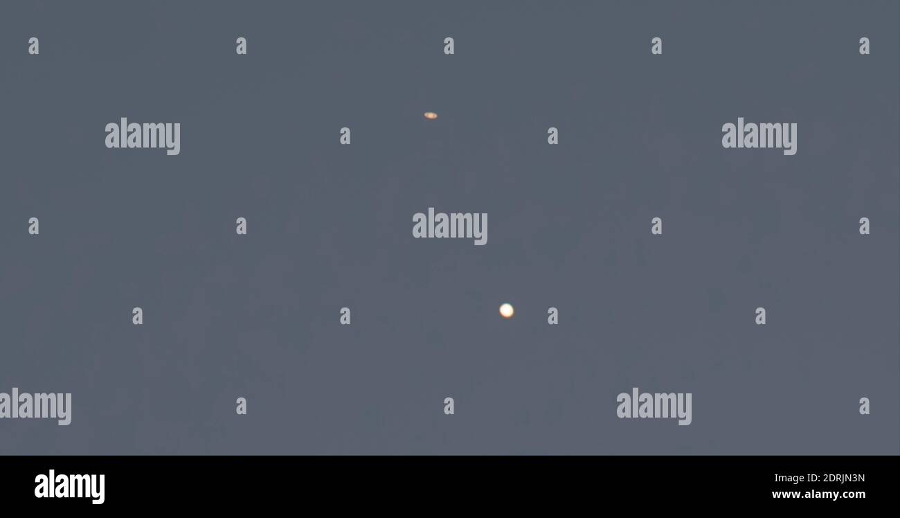 Londres, Royaume-Uni. 20 décembre 2020. La planète annelée Saturne (en haut à gauche) et la planète géante Jupiter, avec 3 de ses lunes visibles, apparaissent après le coucher du soleil au-dessus des toits dans le ciel sud-ouest alors qu'ils approchent de la grande conjonction la nuit du 21 décembre - le solstice de décembre. La conjonction semblable précédente des deux planètes dans cette distance visible de la Terre était il y a 800 ans. Les deux planètes sont, néanmoins, à environ 400 millions de kilomètres l'une de l'autre. Crédit: Malcolm Park/Alay Banque D'Images