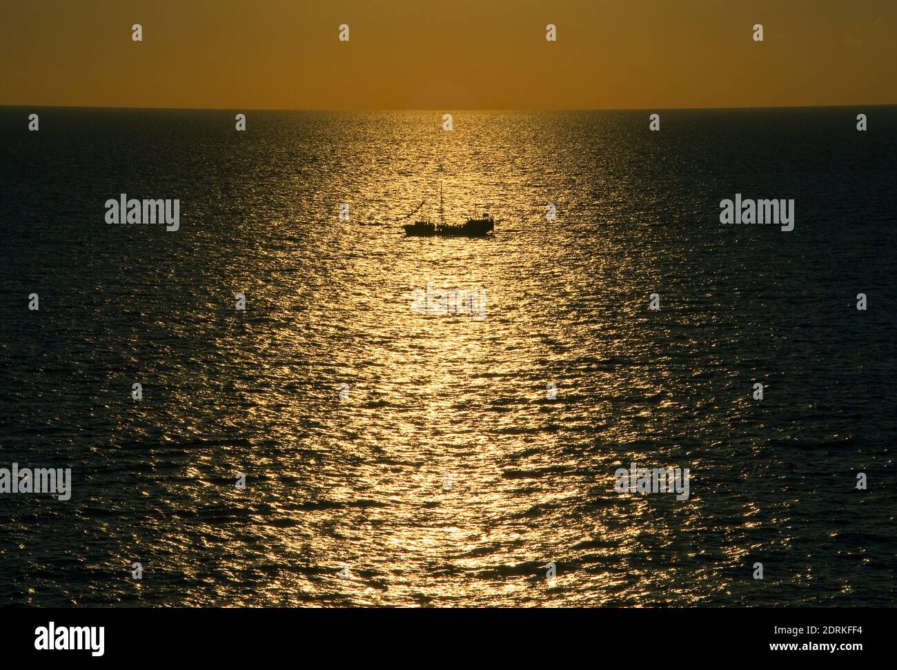 Bateau à voile en mer au coucher du soleil. Banque D'Images