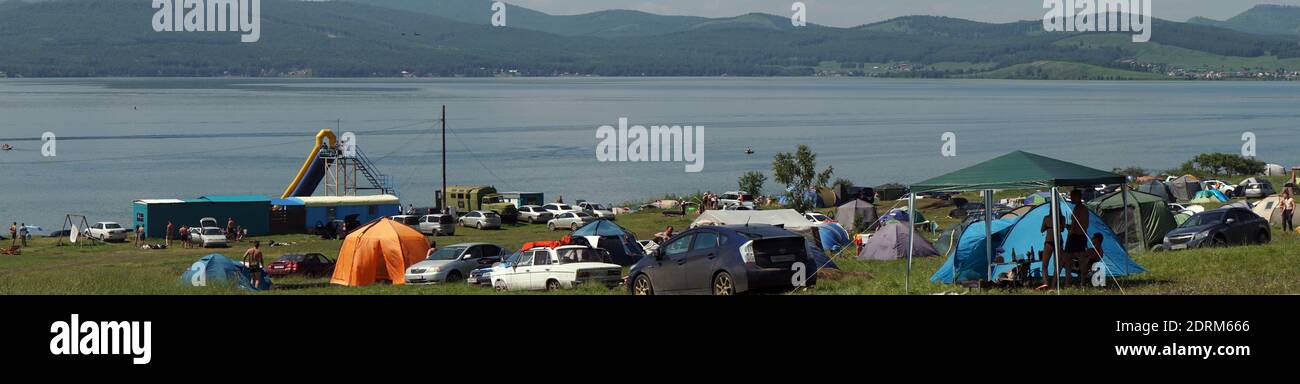 Parnaya, région de Krasnoyarsk, RF - 12 juillet 2020 : les gens se reposent dans des tentes sur la rive d'un grand lac, par une chaude journée d'été pendant leurs vacances. Banque D'Images