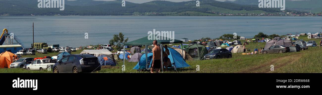 Parnaya, région de Krasnoyarsk, RF - 12 juillet 2020: Personnes se reposant au camping sur la rive d'un grand lac lors d'une chaude journée d'été pendant leurs vacances. Banque D'Images
