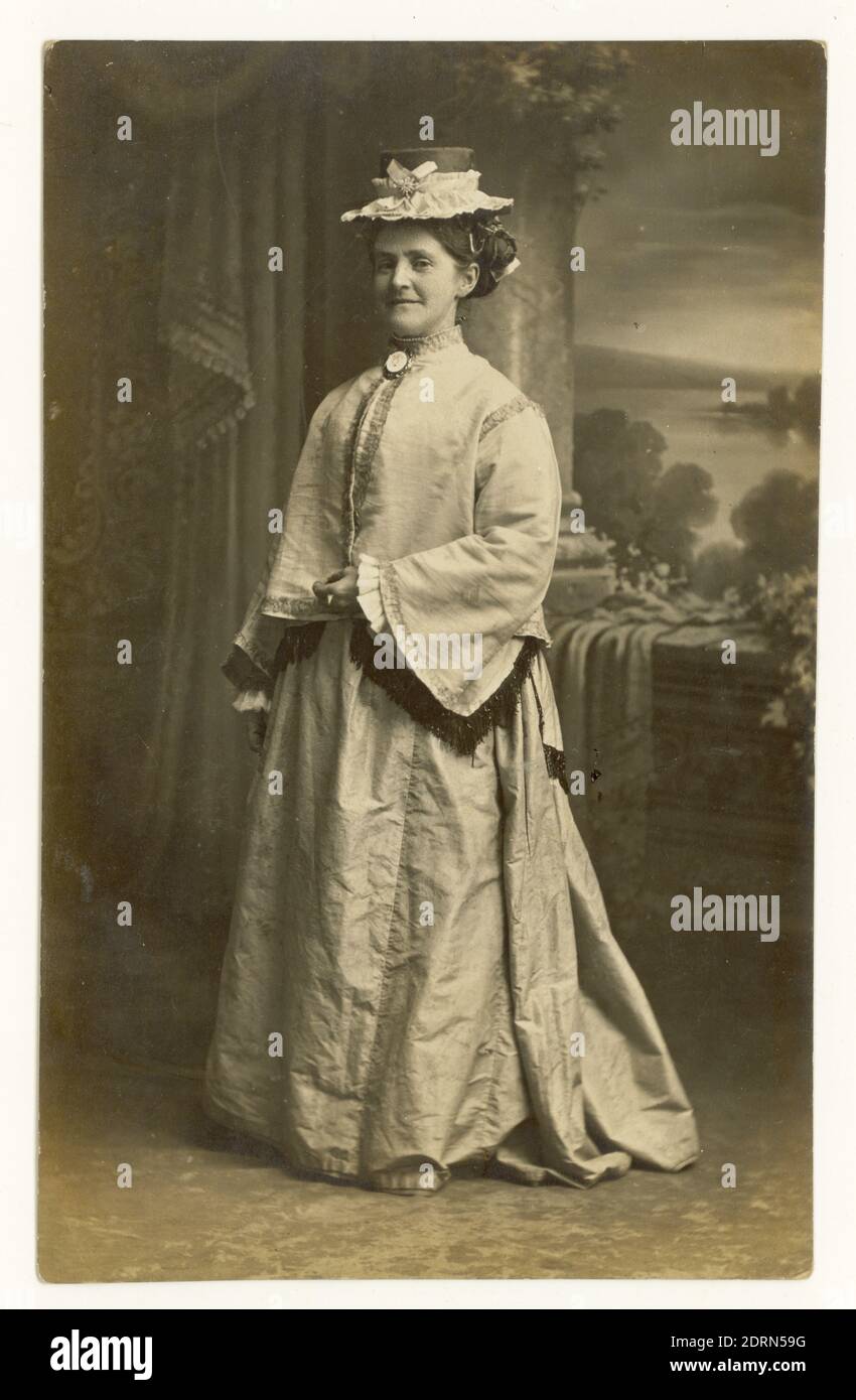 Carte postale édouardienne de la femme édouardienne souriante de l'époque victorienne posant dans une robe de fantaisie, vers 1910, U.K Banque D'Images