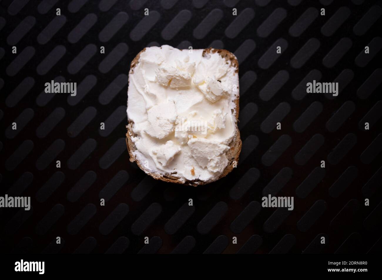Morceau de pain rustique avec seulement de la crème aigre. Concept de pauvreté et de faim Banque D'Images