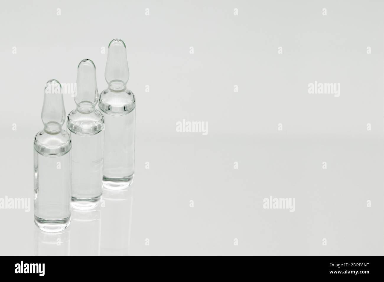 Ampoules en verre liquide, isolées sur fond blanc. Banque D'Images