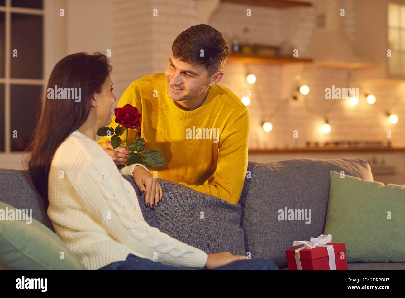 Jeune homme souriant petit ami ou mari lui donnant des fleurs Femme petite amie ou femme pour la Saint Valentin Banque D'Images
