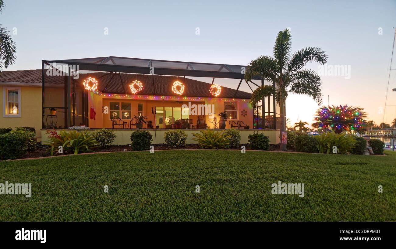 Maison décorée avec des lumières de Noël, arrière, lanai grillagé, palmiers, herbe, arbustes, vacances, festif, Floride, PR Banque D'Images