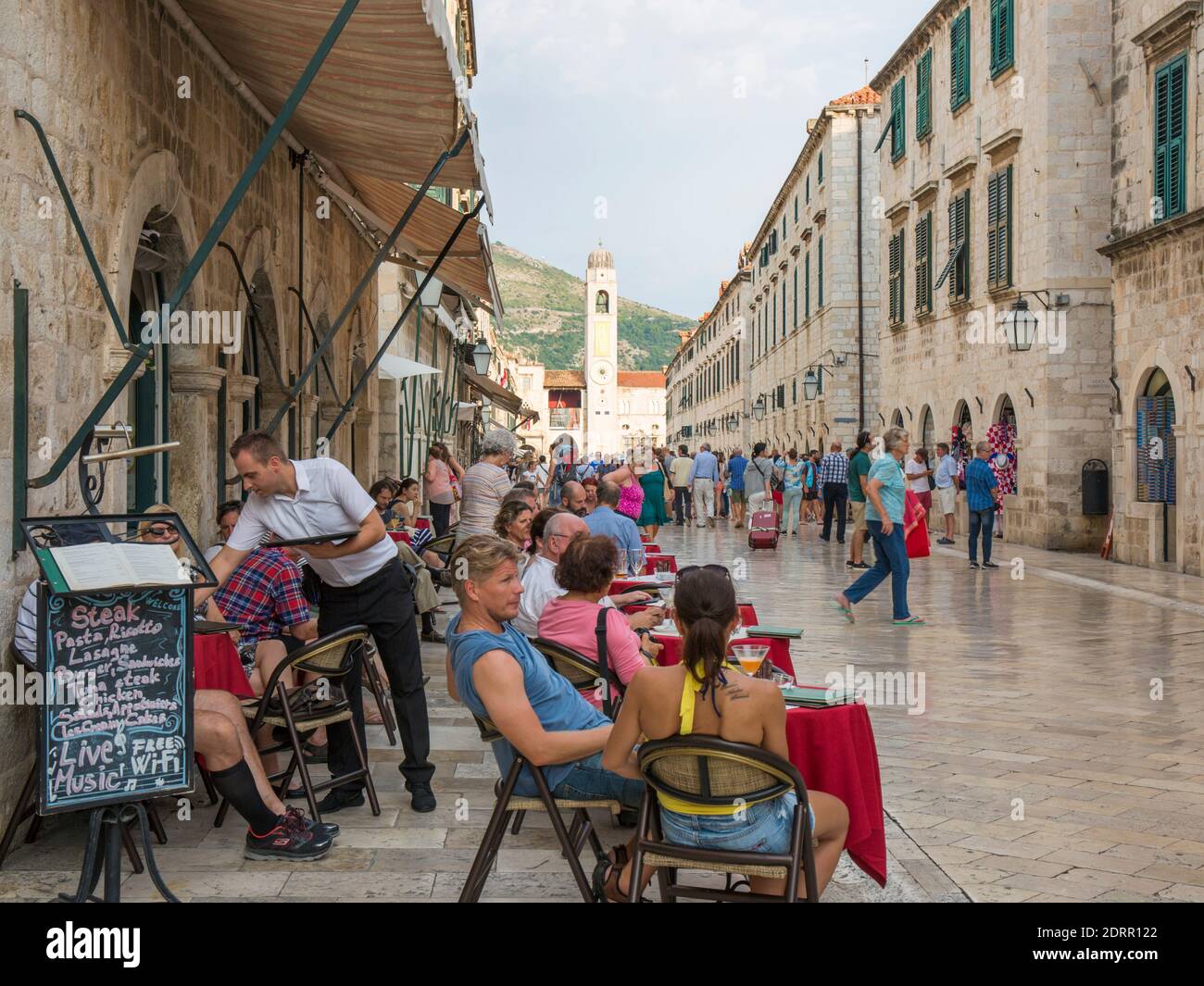 Dubrovnik, Dubrovnik-Neretva, Croatie. Les touristes se détendent dans un café sur le trottoir à Stradun. Banque D'Images