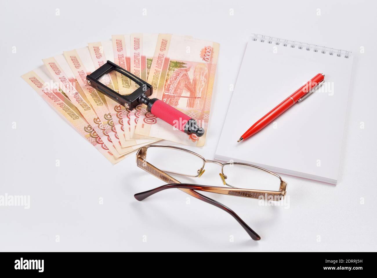 Inspection minutieuse avec une loupe des billets et notes papeterie et de l'argent. Banque D'Images