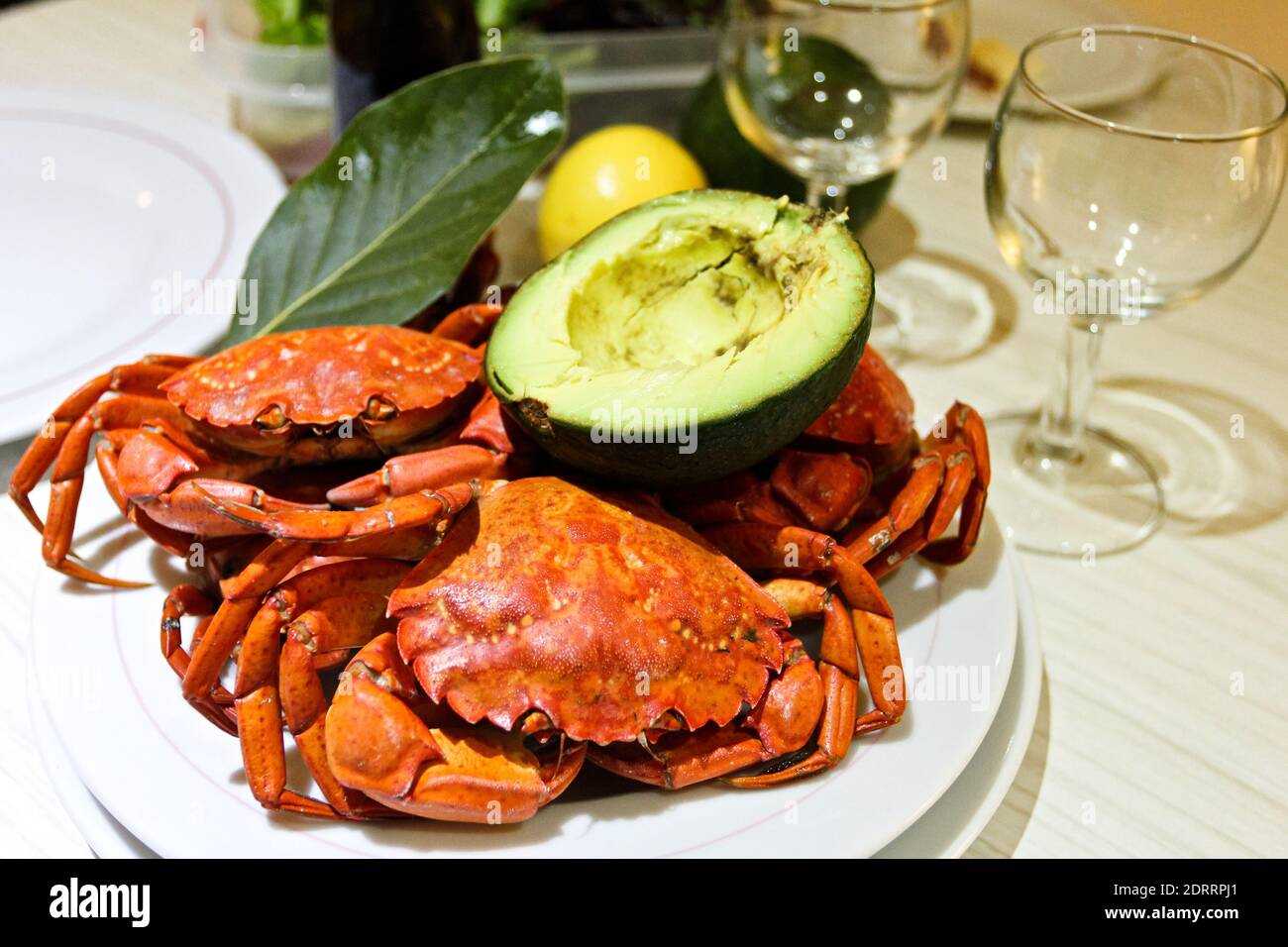 Gros plan crabes rouges bouillis, avocat, Laurier, verres à vin Banque D'Images