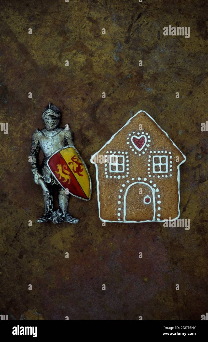 Modèle de maison en pain d'épice avec modèle de chevalier médiéval armure debout à côté Banque D'Images