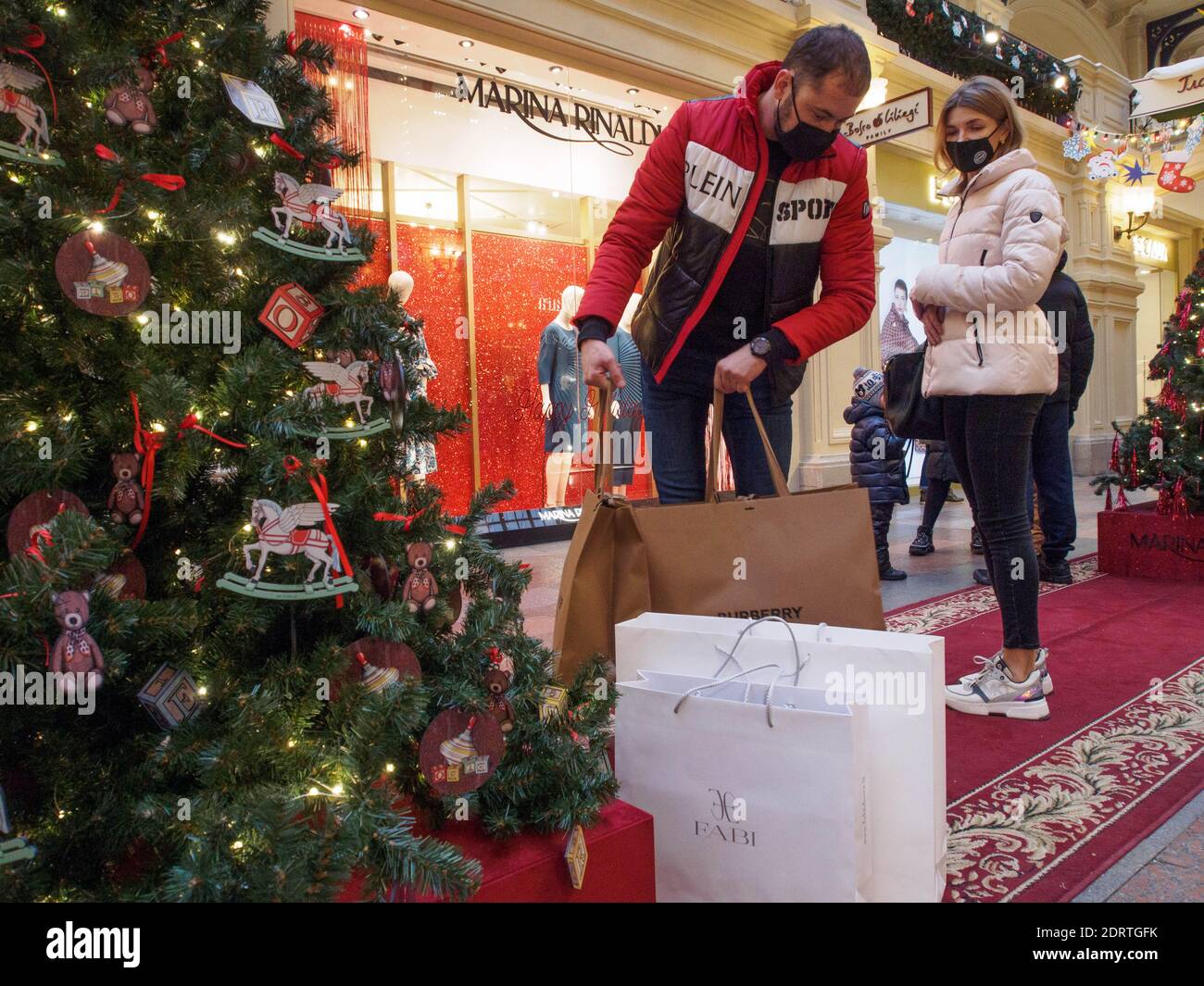 GUM shoppers vu avec des sacs d'achats.en décembre, le grand magasin principal du pays, GUM, a célébré son 127e anniversaire. C'est un endroit incontournable pour les résidents et les visiteurs de Moscou. Traditionnellement, au nouvel an, LA GOMME est transformée en un pays fabuleux, et devant sa façade, sur la place Rouge, une patinoire est ouverte tout l'hiver. Banque D'Images