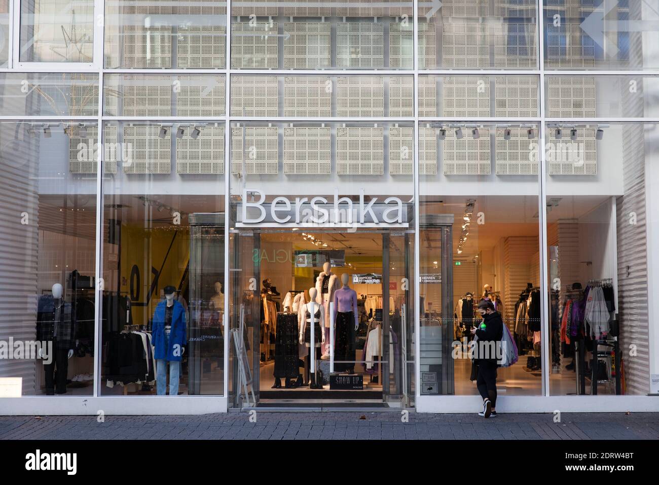 Corona Lockdown, 17 décembre. 2020. Femme en face du magasin fermé Bershka  sur la rue commerçante Schildergasse, Cologne, Allemagne. Corona Lockdown  Photo Stock - Alamy