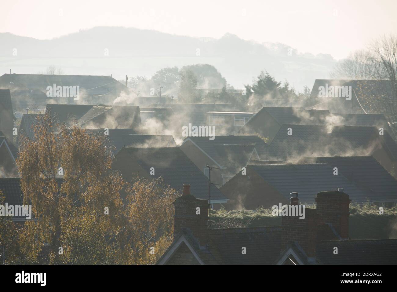 La vapeur qui s'élève des systèmes de chauffage et des toits est réchauffée par le soleil du matin après une nuit froide. Angleterre GB Banque D'Images