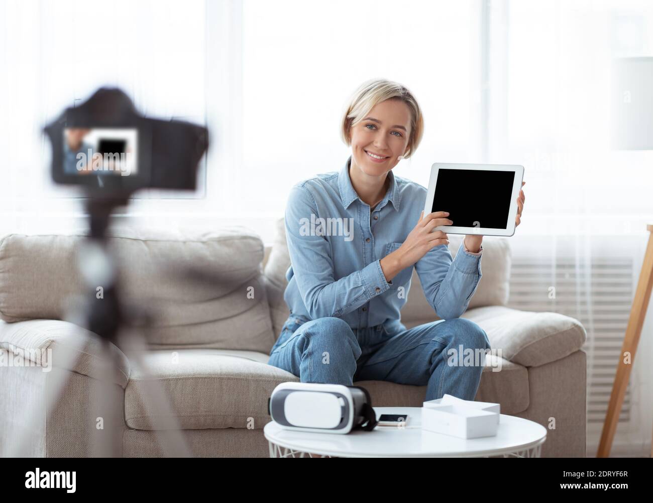 Influenceur féminin qui passe en revue la vidéo du nouvel ordinateur tablette, fait la promotion du nouveau modèle de gadget, en utilisant un appareil photo professionnel Banque D'Images