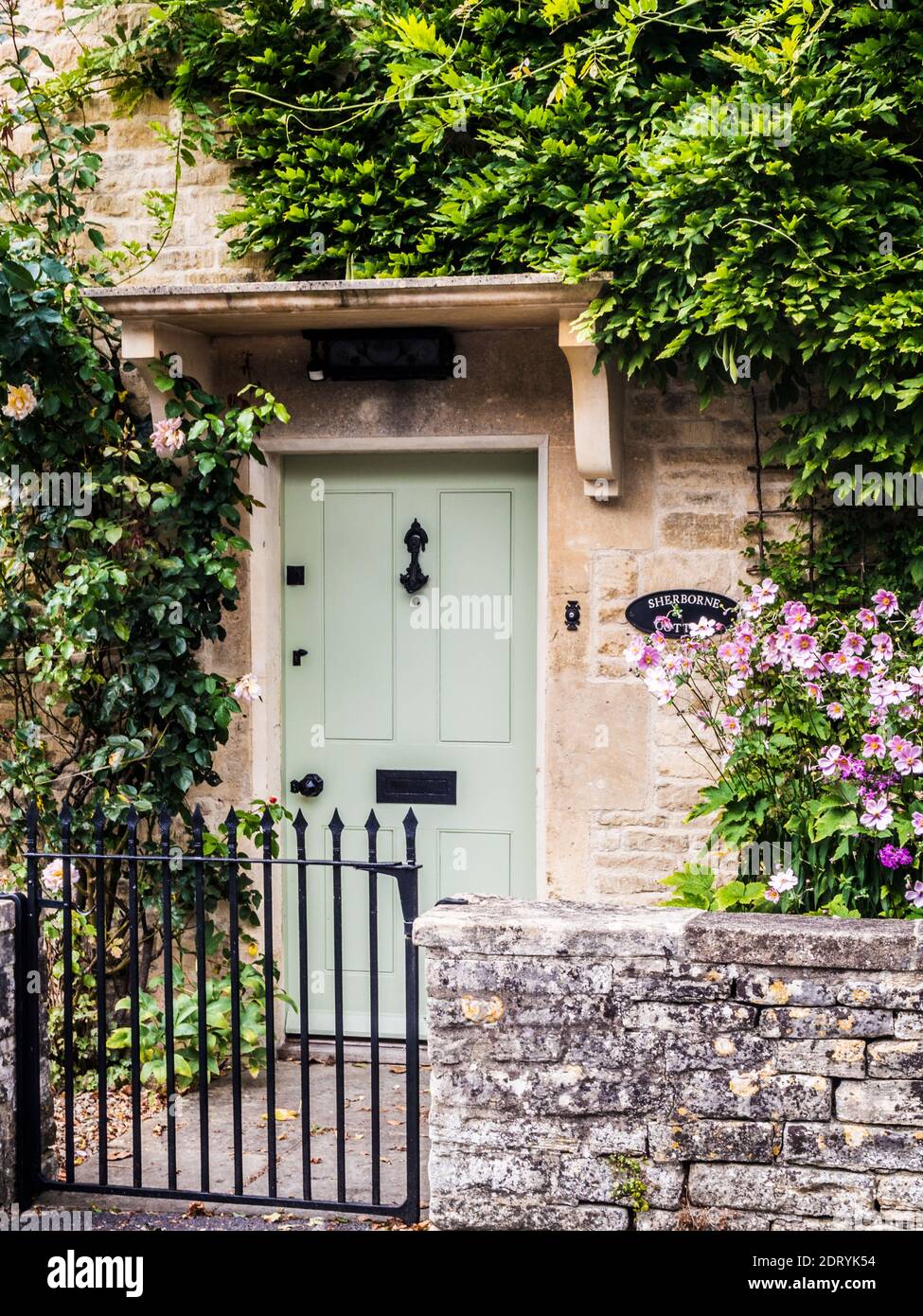 La porte d'entrée d'un joli cottage en pierre Cotswold. Banque D'Images