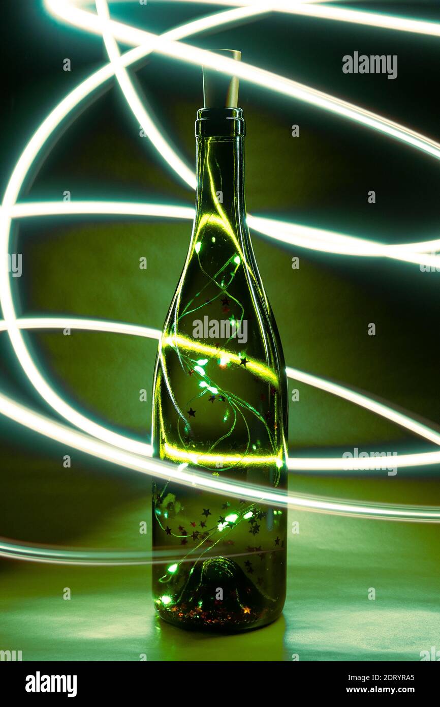 Lumières en forme de bouteille avec liège, guirlande en bouteille de verre pour le vin. Mise au point sélective, vue verticale Banque D'Images