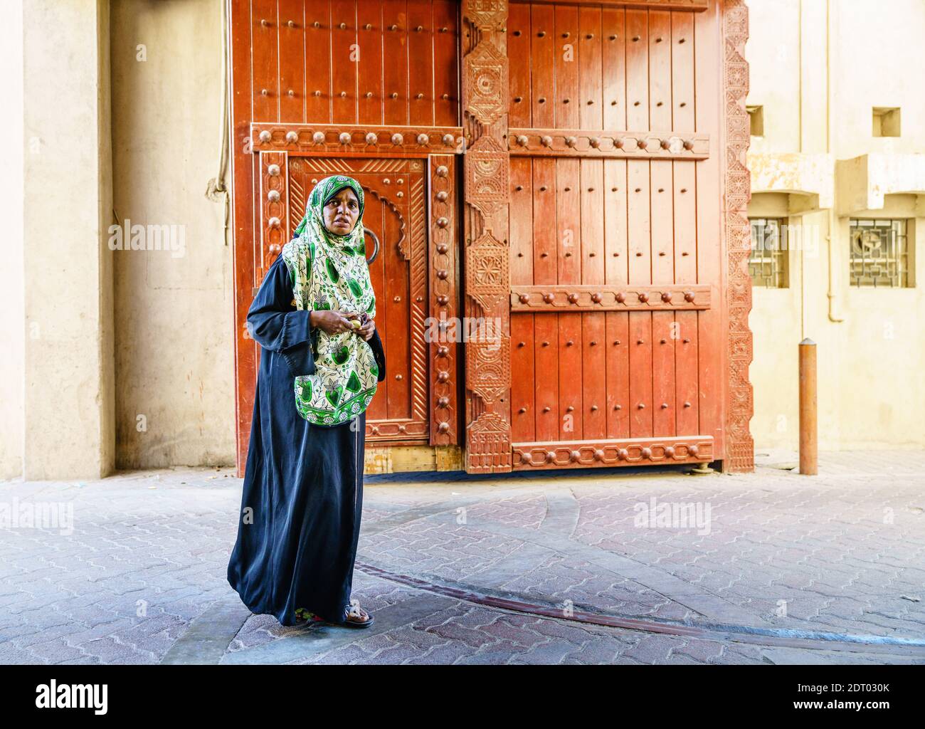 Nizwa, Oman, le 2 décembre 2016 : une femme locale d'âge moyen traverse les portes de la ville au marché du vendredi à Nizwa, Oman Banque D'Images