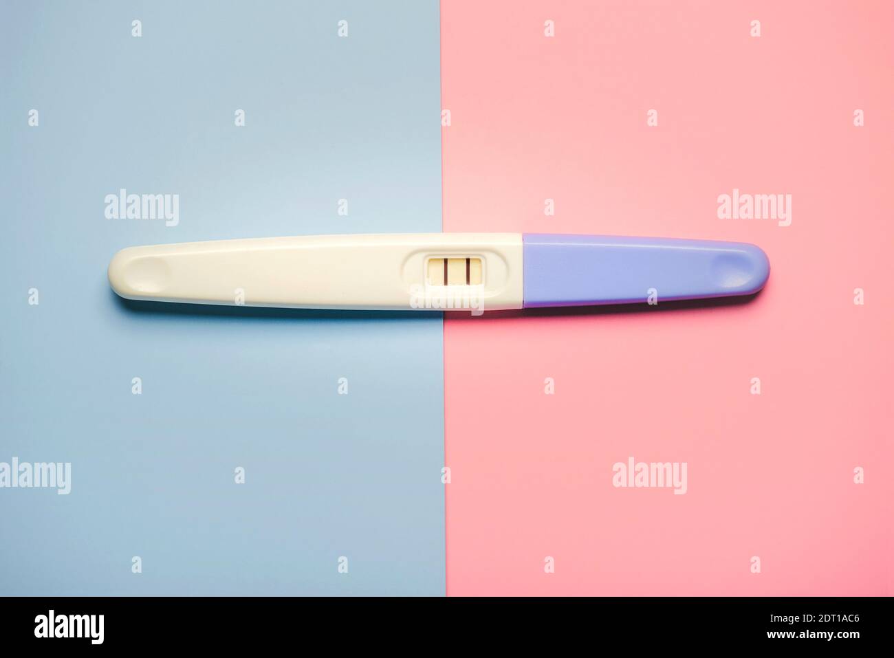 test de grossesse positif avec deux bandes sur un rose et arrière-plan bleu Banque D'Images